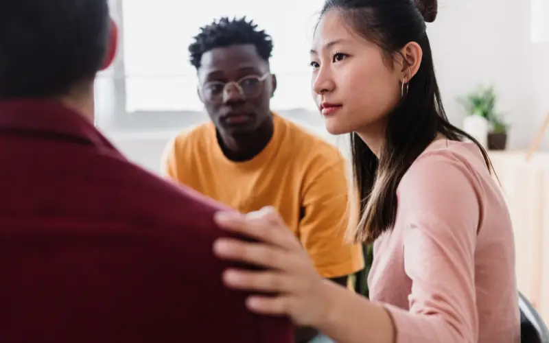 A diverse group of young people in a therapy session.