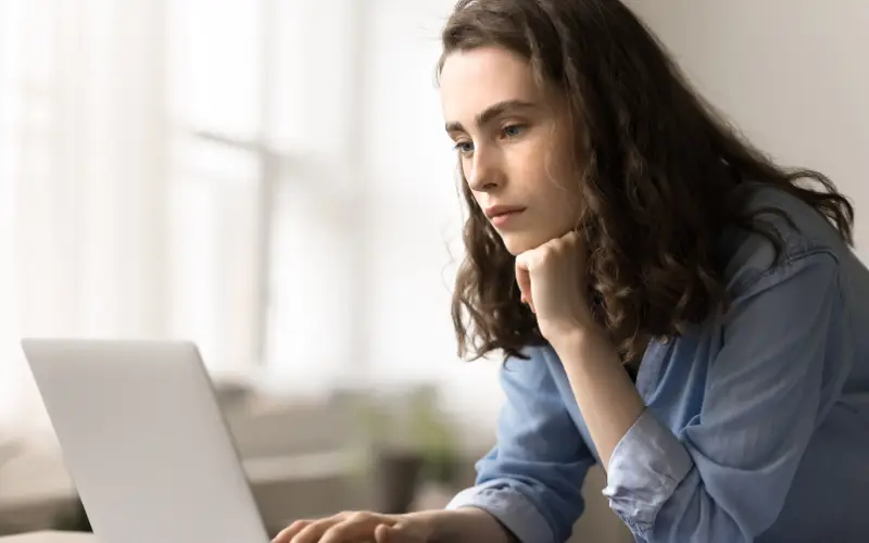 A woman uses a laptop to look for information on suicide prevention.