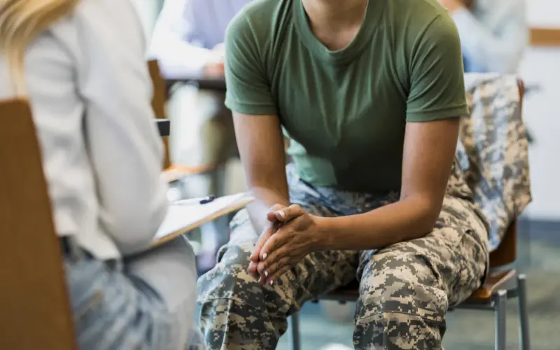 A veteran sits in a therapy session and talks to a therapist.