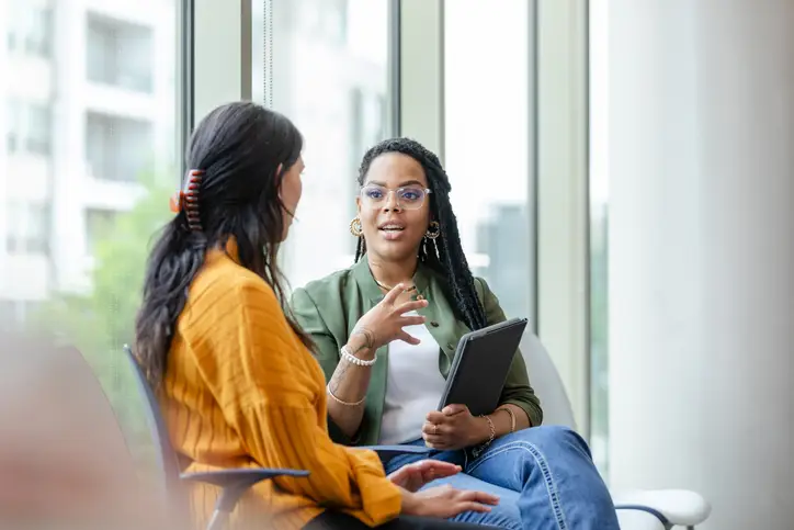 A woman in therapy listens attentively to a woman therapist.